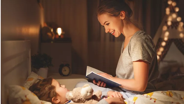 mother-and-child-reading-book-in-bed-before-going-to-sleep-picture-id965212880