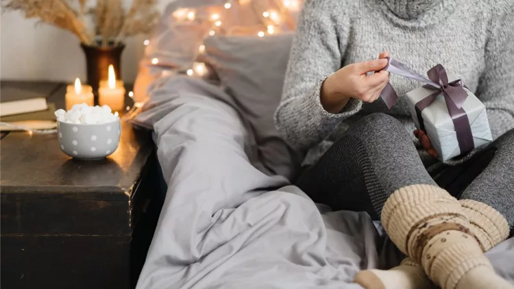 woman-holding-gift-in-cozy-room-merry-christmas-picture-id1182142761