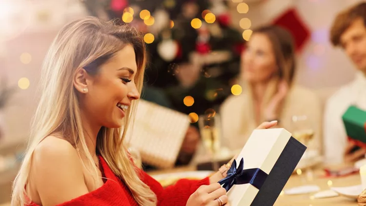 Group of friends giving Christmas presents at home