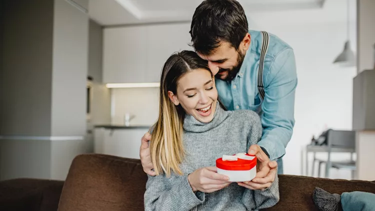 Young romantic couple holding present