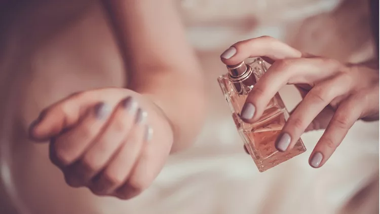 woman-applying-perfume-on-her-wrist-picture-id520136963