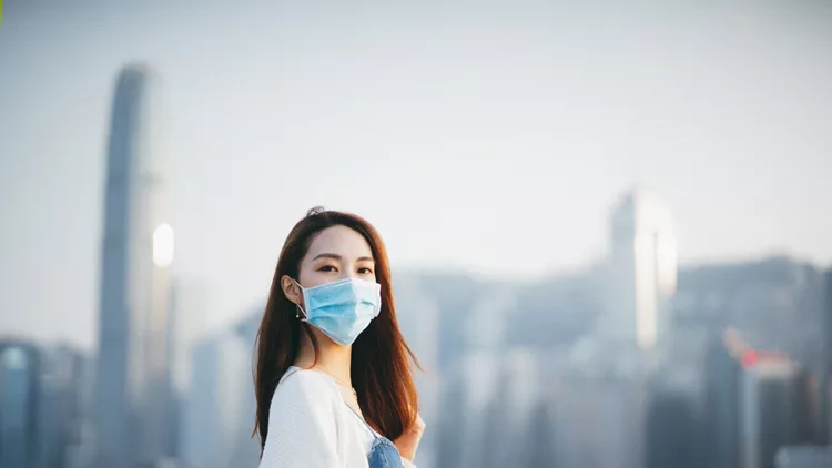 Young Asian woman wearing a protective face mask to prevent the spread of coronavirus, a global health emergency over outbreak