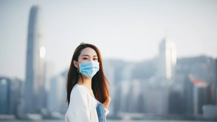 Young Asian woman wearing a protective face mask to prevent the spread of coronavirus, a global health emergency over outbreak
