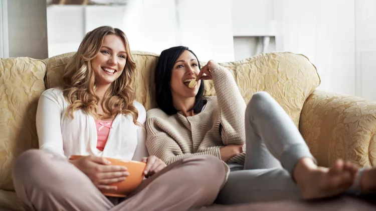 Women sitting on sofa watching a movie
