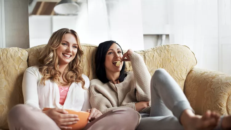 Women sitting on sofa watching a movie