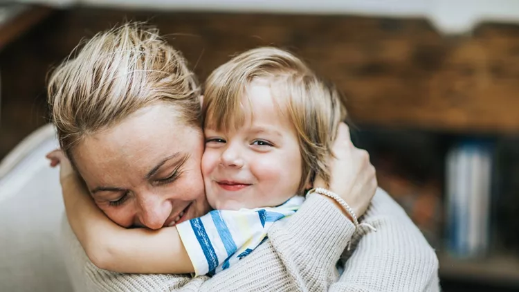 Affectionate mother and son embracing at home.