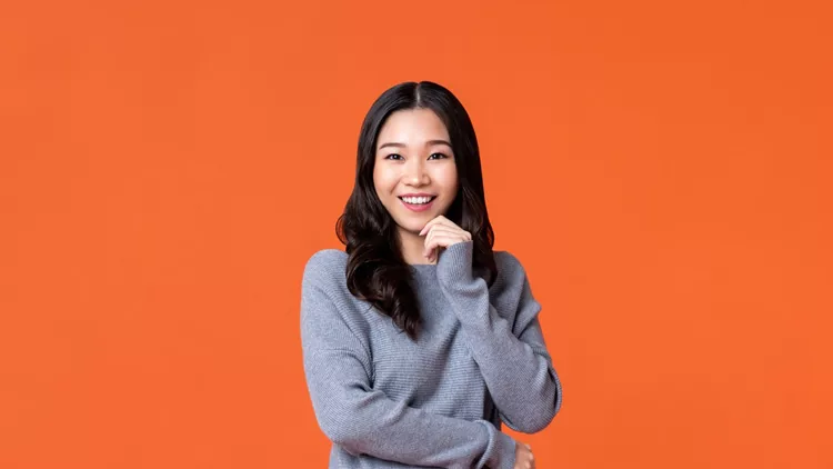 Happy Asian woman smiling with hand on chin