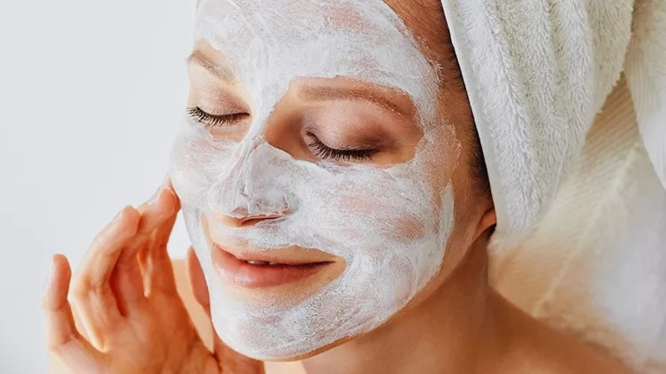 Beautiful young woman with facial mask on her face