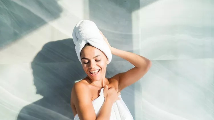 Portrait of beautiful woman wearing bathrobe and towel on head after shower at home