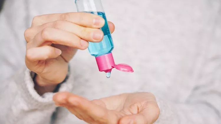 Woman using hand sanitizer