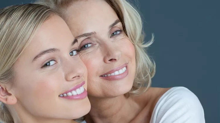 Close up portrait of smiling mother and daughter hugging