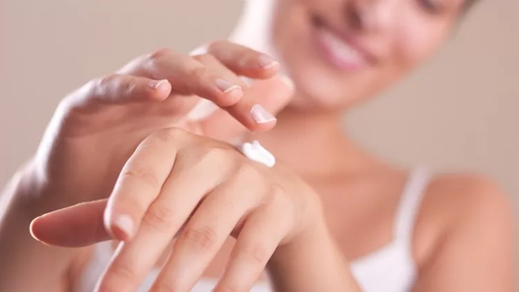A woman applying hand lotion onto her hands