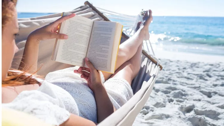 brunette-reading-a-book-while-relaxing-in-the-hammock-picture-id481677580(1)