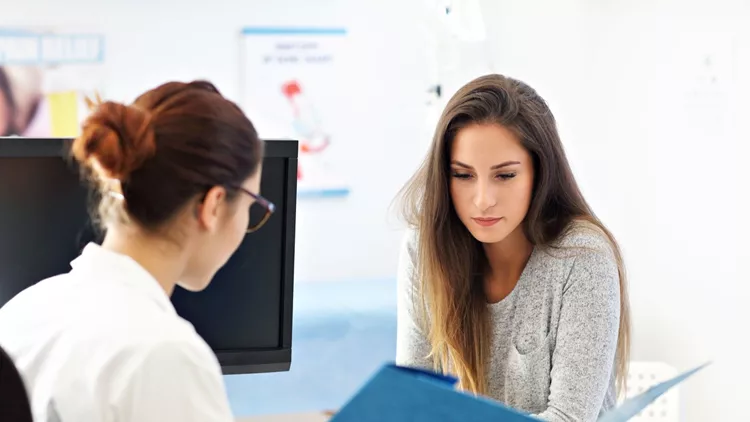 Adult woman having a visit at female doctor's office