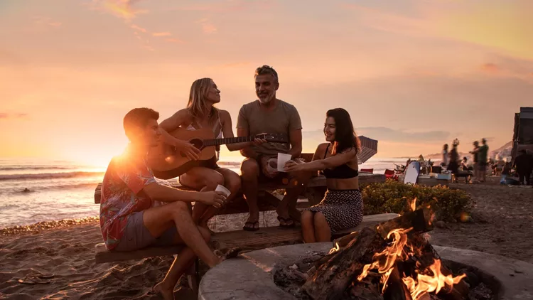 Family party on the beach in California at sunset