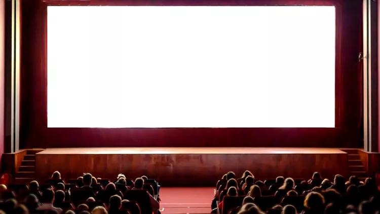 People in the cinema auditorium with empty white screen.