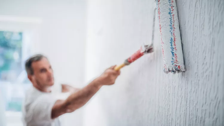 Painter man at work with a paint roller