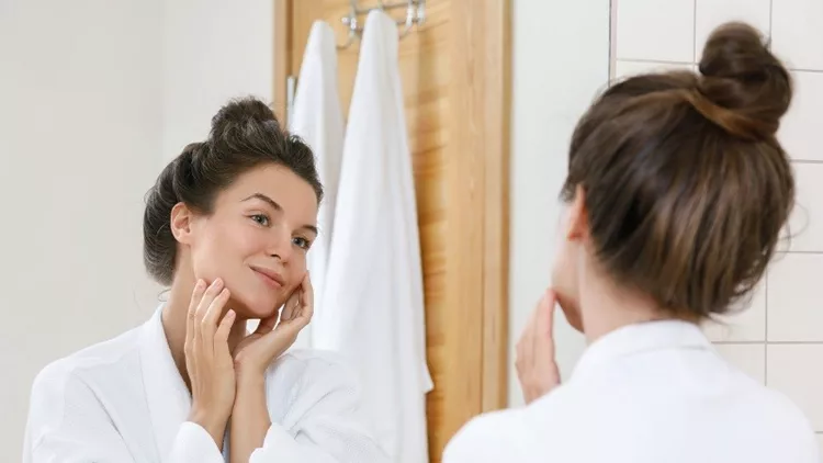 Young woman looking into the mirror