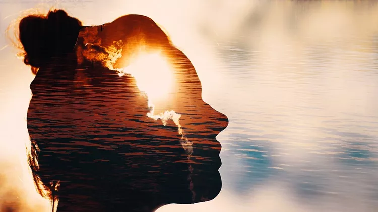 Sun peeks out from behind the clouds in woman's head