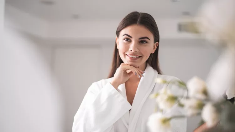 Happy woman watching at reflection in apartment