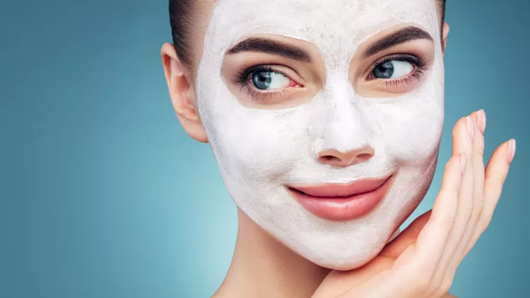 Happy young girl with facial mask on her face