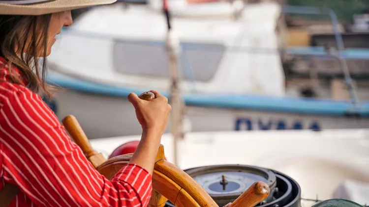 Woman Solo traveler at the quay of a small fishermen village.