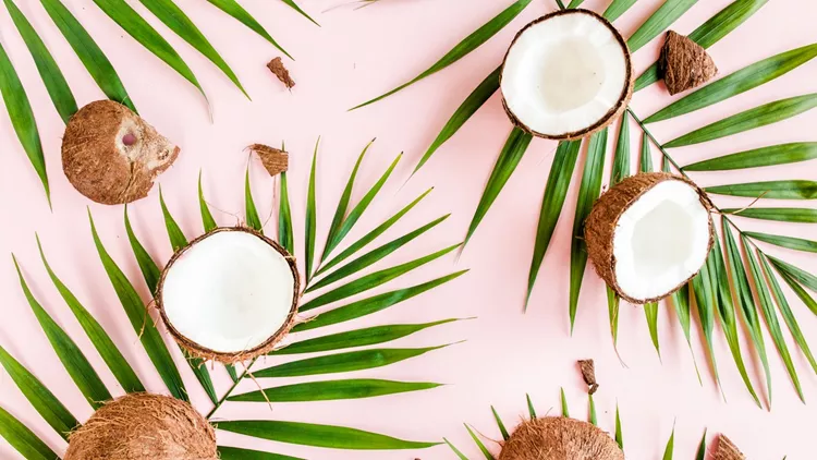 Pattern, texture with coconuts and tropical palm leaves on pink background. Tropical abstract background. Flat lay, top view