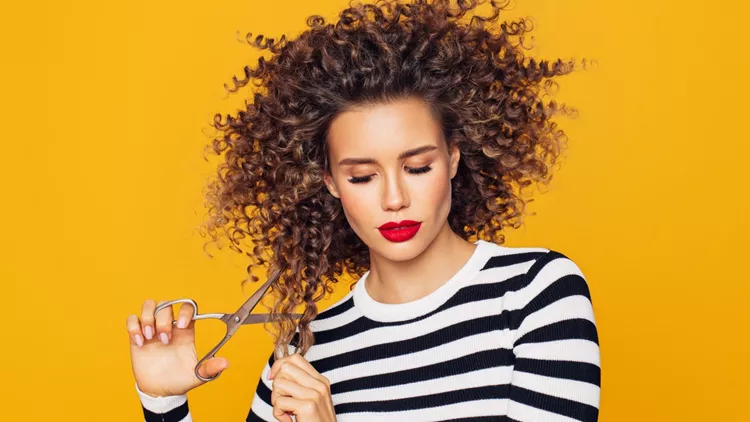 Close-up photo of a beautiful girl holds hair scissors and ready to change her hairstyle