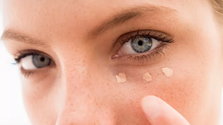 Woman applying concealer