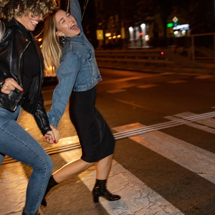 Drunk female friends crossing the street