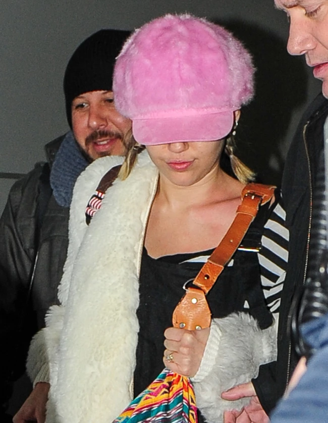 Miley Cyrus hides and smiles while her huge eyes peek out of behind a huge colorful purse and huge pink cap in NYC. Pictured: Miley Cyrus Ref: SPL1186204 170116 Picture by: @PapCultureNYC / Splash News Splash News and Pictures Los Angeles: 310-821-2666 New York: 212-619-2666 London: 870-934-2666 photodesk@splashnews.com 